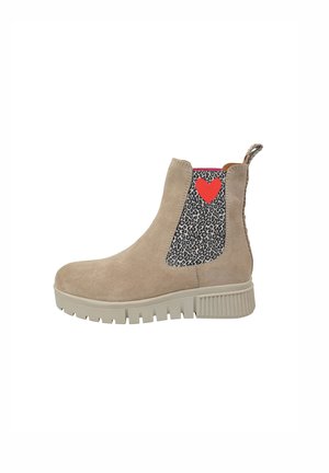 Beige suède enkellaars met een textuurpaneel in zwart-wit luipaardprint en een rode hartaccent. Dikke zool met geribbeld rubber profiel.