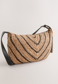 Borsa a spalla intrecciata in paglia con strisce nere, caratterizzata da una forma curva e una tracolla in pelle. Superficie strutturata con finitura naturale.