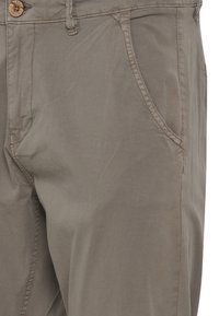 Beige bomullsmix bukser med glidelås, knapplukking og frontlommer; jevn tekstur og skreddersydd design med sydd detaljer.