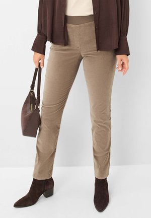 Beige Corduroy-Hosen mit elastischem Bund, kombiniert mit einer dunkelbraunen Bluse und Stiefeletten. Sie verfügen über einen strukturierten Stoff und ein tailliertes Design.