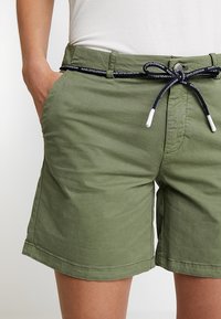 Olivově zelené šortky vyrobené z lehkého materiálu, s bočními kapsami, páskem s námořnickou šňůrkou a prošitými detaily na lemu.