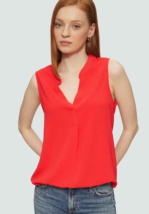 Blouse rouge sans manches avec un décolleté en V, fabriquée en tissu léger. Texture lisse, coupe décontractée et détails de forme subtils au niveau du col.