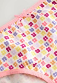 Tissu doux avec un motif répétitif de petites fleurs multicolores en jaune, orange, rose, violet et rouge, avec une finition en couture rose et un petit nœud.