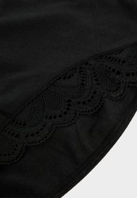 Schwarzes Oberteil mit einem gewellten Spitzenrand, das mit detaillierten Mustern und Ausschnitten verziert ist, aus weichem Stoff mit glatter Textur.