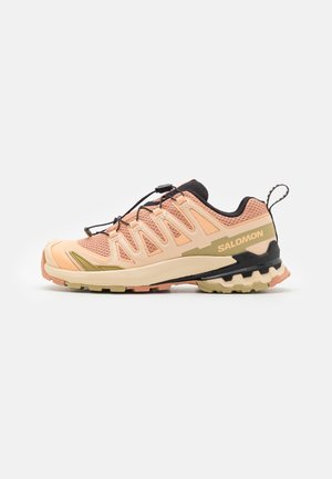 Hellrosa und beige Trail-Running-Schuh mit schwarzen Akzenten, robuster Sohle, elastischem Schnürsystem und Zuglasche an der Ferse.