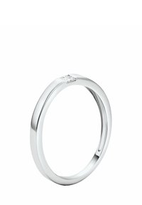 Strieborný prsteň s hladkým, okrúhlym pásikom a malým diamantovým akcentom umiestneným v trojuholníkovom tvare vpredu. Lesklý povrch, elegantný dizajn.