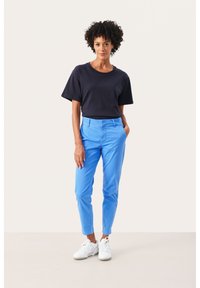 Navy t-shirt with short sleeves, paired with bright blue, slim-fit pants and white sneakers. Simple design, smooth texture, and solid colors.