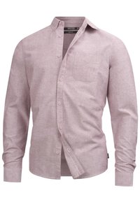Chemise boutonnée à manches longues de couleur rose pâle, en tissu texturé, avec une poche poitrine, un col classique et une fermeture à boutons.