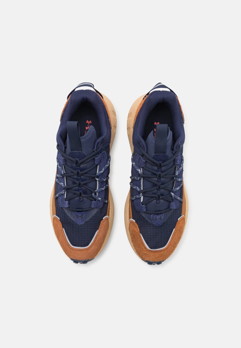 Navy reklamówki i zamszowe sneakersy z brązowymi akcentami, teksturowanymi nakładkami, wyściełanym językiem i odblaskowymi sznurowadłami. Trwała gumowa podeszwa.