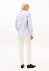 Lichtblauw gestreept overhemd met lange mouwen en een button-down kraag, gecombineerd met witte broek en zwarte schoenen; gladde stof en rechte pasvorm.