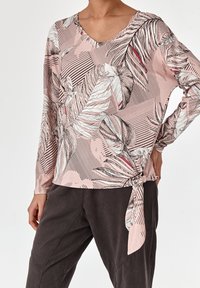 Langärmliges Oberteil in Rosa mit floralem und gestreiftem Muster, mit V-Ausschnitt und einer gebundenen Akzentuierung an der Taille. Weicher, leichter Stoff.