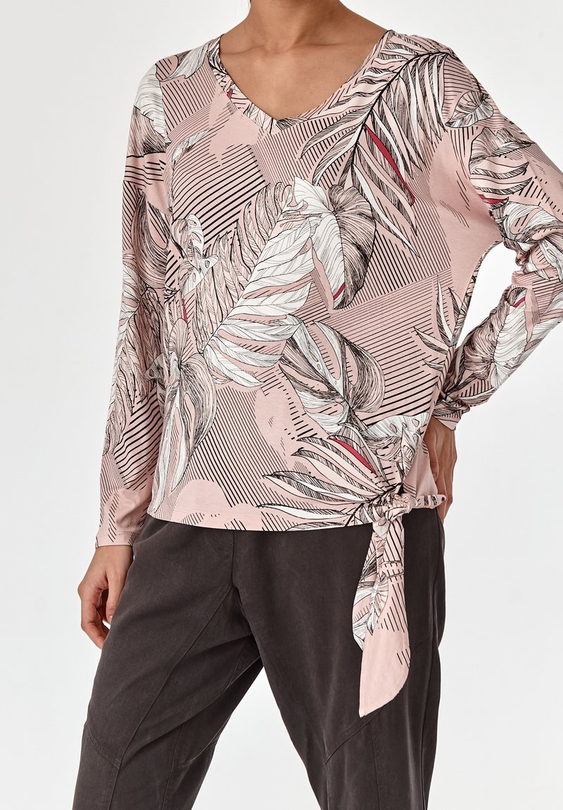 Langärmliges Oberteil in Rosa mit floralem und gestreiftem Muster, mit V-Ausschnitt und einer gebundenen Akzentuierung an der Taille. Weicher, leichter Stoff.