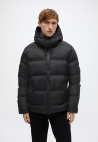 Μαύρο μπουφάν puffer με ψηλό γιακά και ρυθμιζόμενη κουκούλα. Διαθέτει λεία ύφασμα, ψηφιδωτό σχέδιο και εμπρόσθιο φερμουάρ.