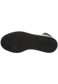 Čierna gumová podrážka tenisky s textúrovaným vzorom a kruhovými akcentmi, s embosovaným logom "adidas".