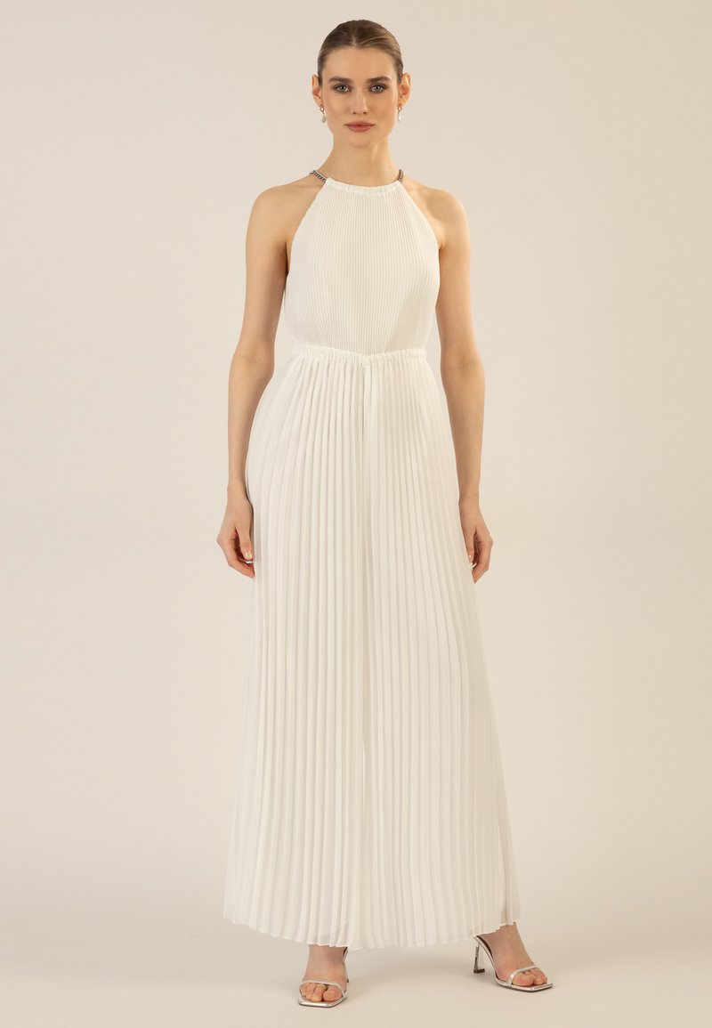 Weißer, plissierter Jumpsuit mit einem Halterneck und elastischem Bund, ausgestattet mit einem silbernen Akzent am Ausschnitt. Fließender Stoff und weite Beine.