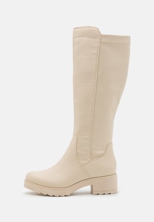 Botte beige montant jusqu'au genou avec petit talon carré, bout rond et semelle texturée, fabriquée en cuir lisse.