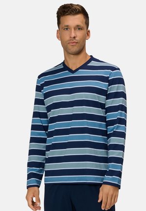 Mann trägt ein langärmeliges V-Ausschnitt-Shirt mit horizontalen Streifen in Blautönen und navyblauen Hosen vor einem einfarbigen Hintergrund.