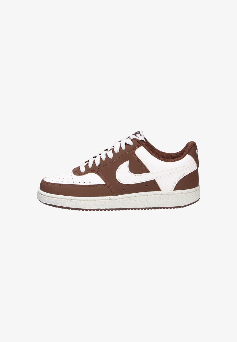 Zapatilla marrón y blanca con parte superior de cuero, puntera perforada, cordones blancos y suela de goma texturizada. Presenta un logo prominente en el costado.