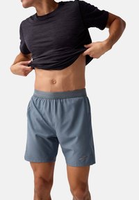 T-shirt de sport pour homme en noir et short en bleu clair, avec une taille élastique, un tissu léger et des poches latérales.