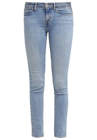 Jean en denim bleu clair avec une coupe ajustée, présentant une taille classique, des poches avant et un délavage minimal. Texture lisse avec une coupe droite.