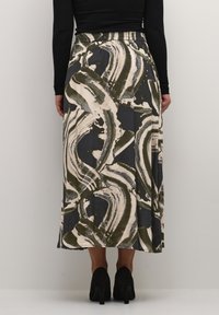 Jupe longue à motifs avec des dessins abstraits de coups de pinceau verts et blancs sur un fond sombre ; taille élastique pour un confort optimal.