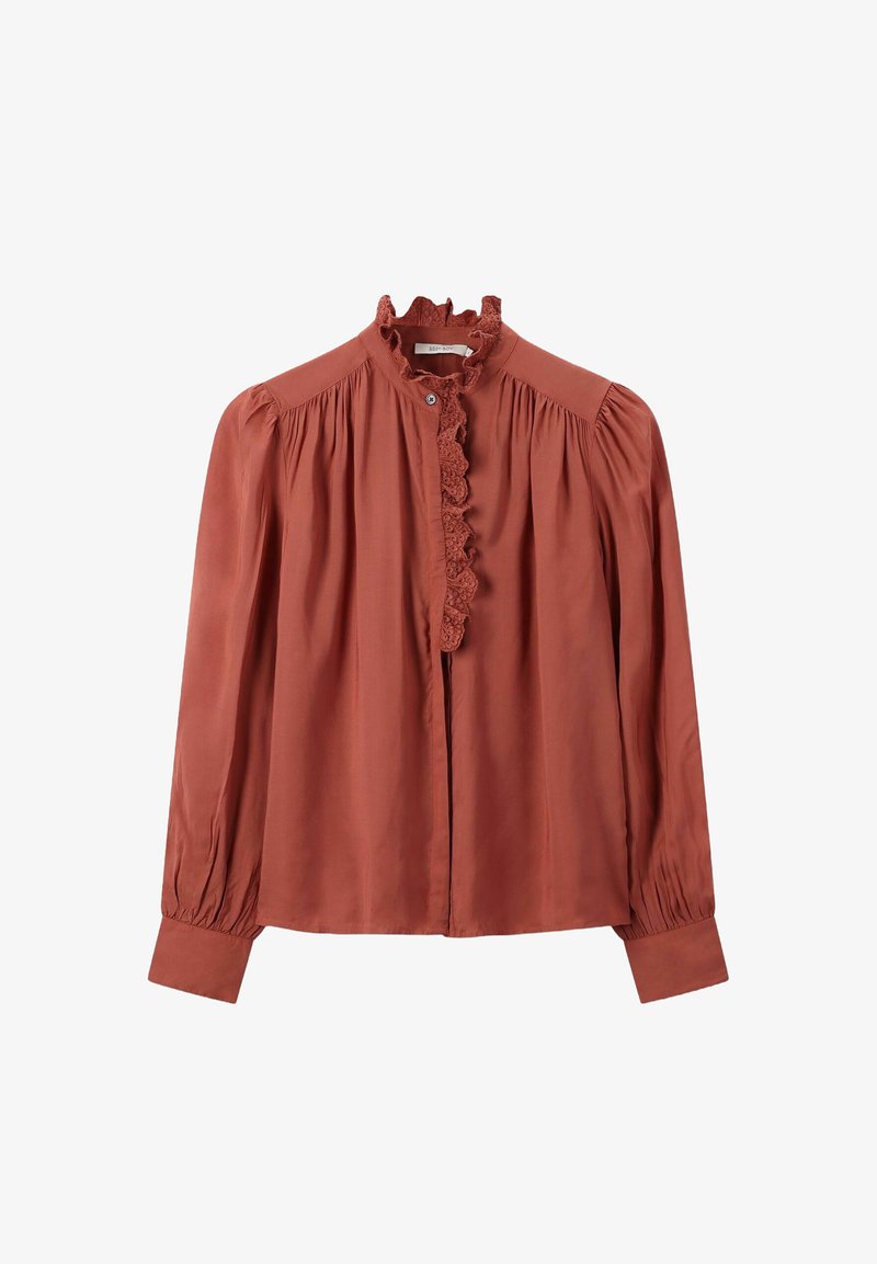 Blouse rouge rouille à manches longues avec col haut bordé de dentelle, épaules froncées, poignets boutonnés et délicates plis le long des manches.