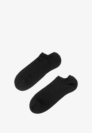 Calcetines negros hasta el tobillo fabricados con un tejido suave, con un diseño sin costuras y puntera redondeada. Sin patrones ni acentos visibles.