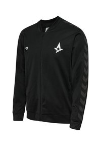 Zwarte zip-up jas gemaakt van gladde stof, met een wit sterrenlogo en chevronpatroon accenten op de mouwen. Inclusief zijzakken.