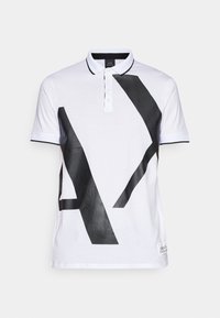 Biała koszulka polo z dużym czarnym wzorem graficznym. Z kołnierzykiem i zapięciem na guziki, czarne wykończenie na rękawach i dekolcie. Wykonana z materiału bawełnianego.