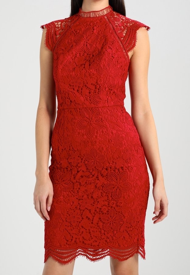 Röd spetsklänning med blommönster och scallopkant. Har hög hals och korta ärmar, åtsittande silhuett. Texturerade, intrikata detaljer.