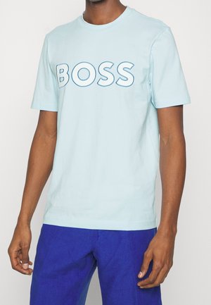 Light blue cotton t-shirt featuring bold "BOSS" text in a slightly darker blue. Short sleeves and a round neckline. Smooth texture.