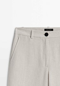 Lichtgrijze linnen broeken met een vlakke voorkant, zijzakken, een knoopsluiting en een merklabel. Gladde textuur met een slanke pasvorm.