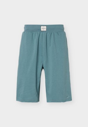 Short de sport bleu sarcelle longueur genou avec taille élastique et petit logo brodé sur l'ourlet gauche.