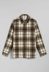 Brązowa, beżowa i czarna, w kratkę, koszula flanelowa zapinana na guziki z długimi rękawami i jedną kieszenią na piersi, ułożona na szarym tle.
