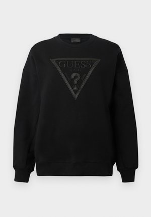 Black crewneck sweatshirt with large black embossed Guess triangle logo and text "GUESS U.S.A. Washed Jeans" on front.