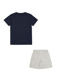 Camiseta de algodón navy de mangas cortas y cuello redondo, combinada con pantalones cortos grises livianos con cinturilla elástica.