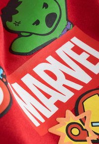 Červená bavlnená látka s rôznymi farebnými kreslenými motívmi, vrátane zelenej postavy, textu "MARVEL" a symbolov akcie.