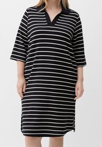 Abito a righe bianche e nere con colletto, maniche a tre quarti, scollo a V, spacchi laterali e taglio morbido. Realizzato in tessuto a coste.