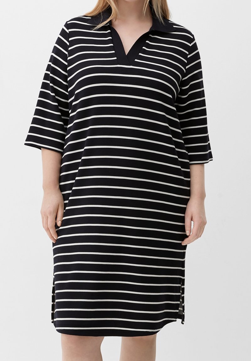 Abito a righe bianche e nere con colletto, maniche a tre quarti, scollo a V, spacchi laterali e taglio morbido. Realizzato in tessuto a coste.