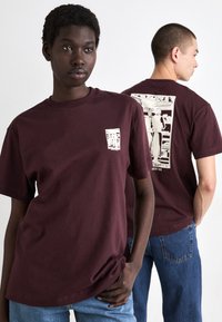 Bordeaux bomull t-skjorte med et lite trykk foran og et større trykk bak. Korte ermer og rund hals design.