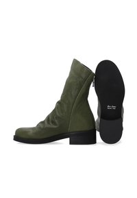 Olivgrüne Lederstiefeletten mit einem lässigen Design, abgerundeter Spitze, niedrigem Blockabsatz und einem Reißverschluss auf der Rückseite; glatte Textur.