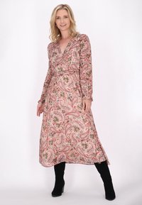 Rochie cu imprimeu floral paisley din material ușor, cu mâneci lungi, decolteu în V, talie strânsă și fustă fluidă. Asortată cu cizme negre.