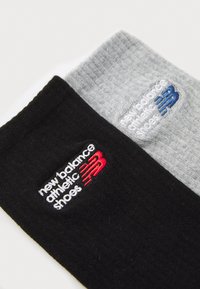 Black and gray athletic socks with embroidered "new balance athletic shoes" logos in red and blue, featuring a textured knit surface.