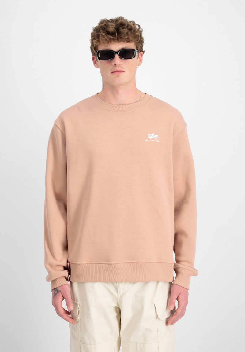 Felpa beige chiaro con scollatura rotonda e polsini a costine. Presenta un piccolo logo bianco sul petto e un tessuto testurizzato.