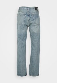 Lichtblauwe denim jeans met een recht model, voorzien van twee achterzakken en een zwart merketiket op de tailleband.