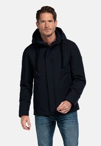 Marineblauwe waterdichte jas met een rits- en drukknoopsluiting, verstelbare capuchon, twee voorzakken en zwarte trekkoorden voor aanpassingen.