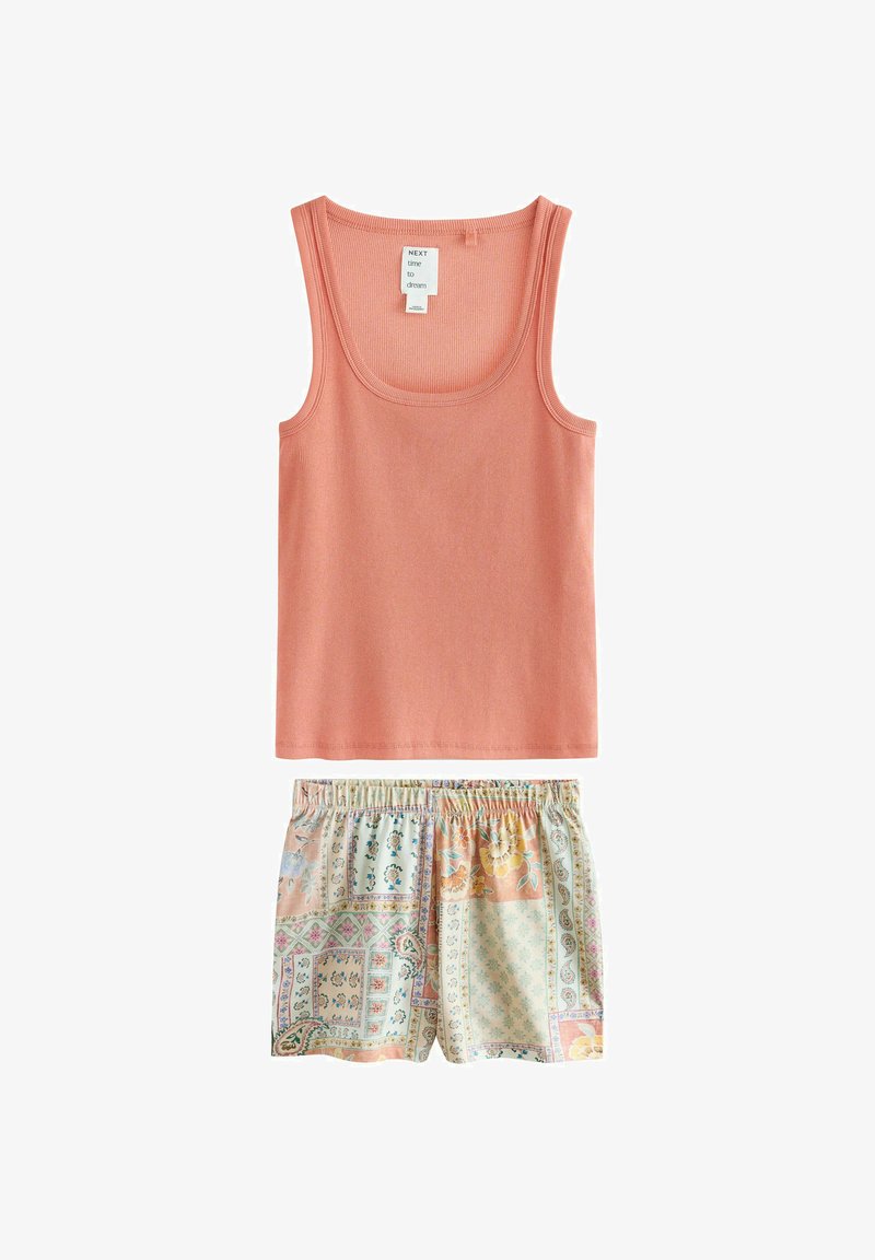 Varrukateta soonikkoes korallroosa topp, mida kannavad elastse vöökohaga lühikesed püksid pastelse lapitehnikas lillemustriga.