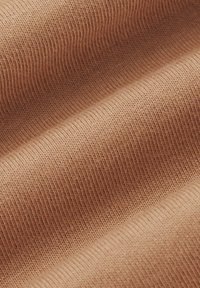 Teksturowana, żeberkowana tkanina w jasnym odcieniu brzoskwiniowym, pokazująca wiele warstw z miękkimi, ściśle tkanymi włóknami i gładkim wykończeniem.