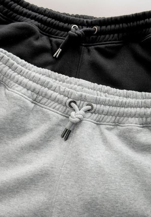 Graue und schwarze Jogginghose mit einem elastischen Bund und Kordelzug. Weicher Stoff mit einer dicken, gerippten Oberfläche am Bund.