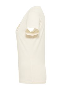 Cream-colored cotton t-shirt with short sleeves, featuring a round neckline and a small embroidered detail on the chest.